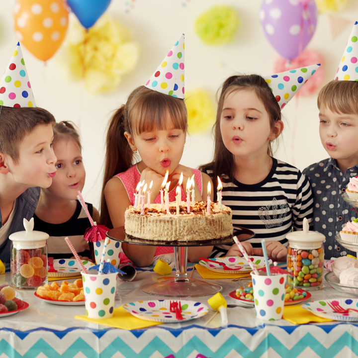 Girl blowing a birthday cake at a birthday party