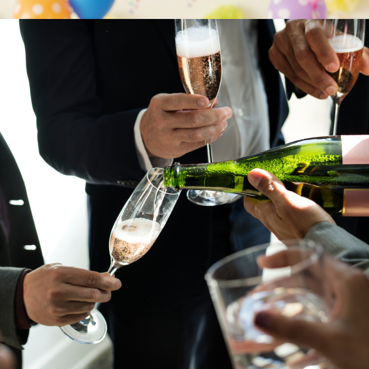 Men wearing suits sharing a bottle of champagne