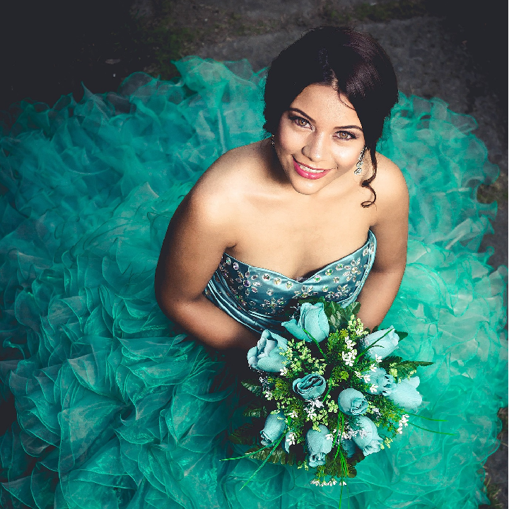 Lady wearing a fluffy blue dress and holding a bouquet of blue roses